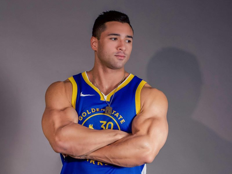 Lean and athletic male model with a sculpted physique standing confidently in a London street fashion setting.