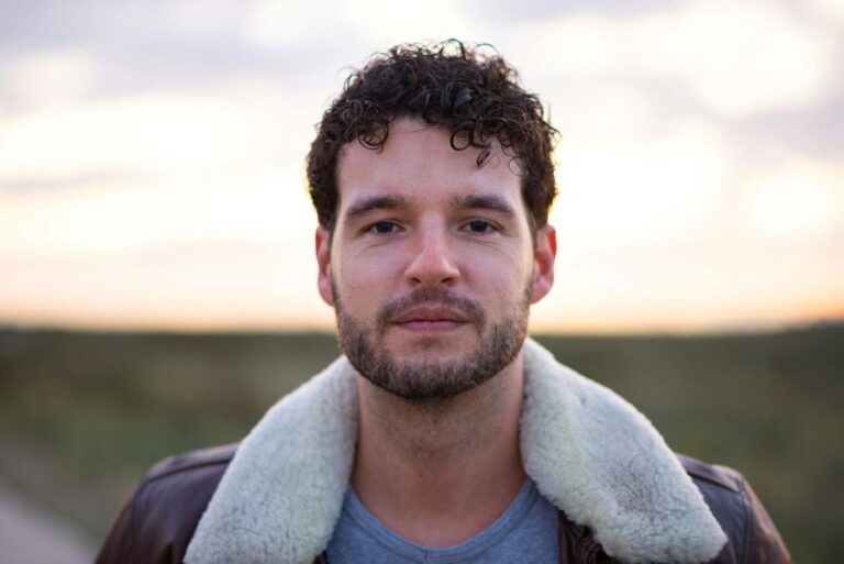 Aspiring male model posing outdoors for a portfolio photoshoot using natural light in the UK