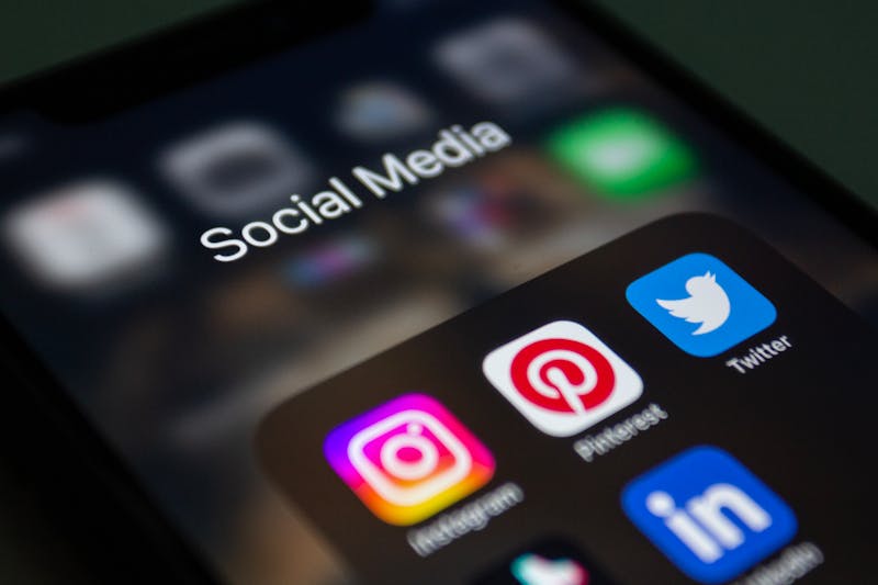 Young UK model reviewing and organising social media profiles on a phone to prepare for agency applications.